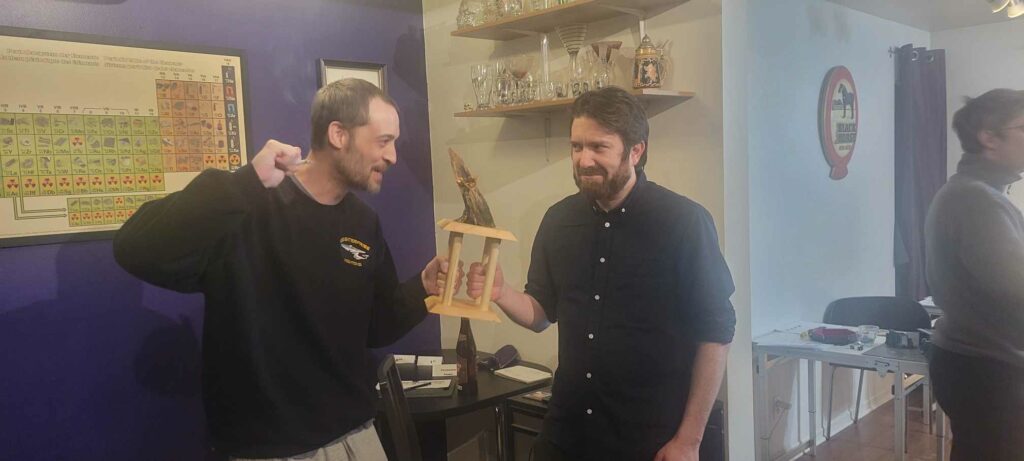 smoky photo of two men holding a warcry trophy and looking ready to fight